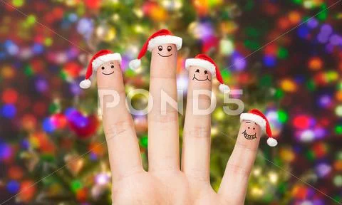 Close up of hand with four fingers in santa hats Stock Photos