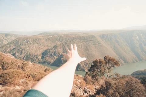 Close up of a hand in front of a super massive river in the middle of the f.. Stock Photos