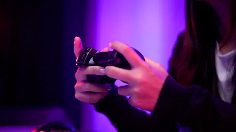 Close-up hand gamer with controller on keyboard. Woman sitting on chair. Stock Footage 175698824