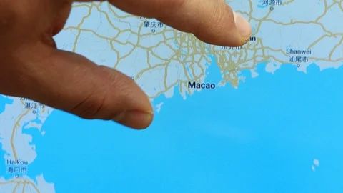 Close up hand gesture on touch screen zoom in Macao city China Stock Footage 128461179