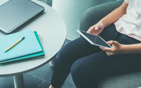 Close up hand of girl sitting and touch blank screen of tablet computer with  Stock Photos