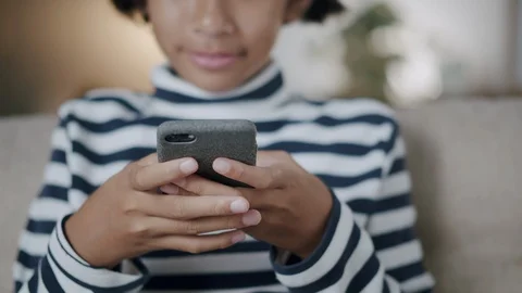 Close-up of hand girl using smartphone while sitting on the sofa Stock Footage 126367730