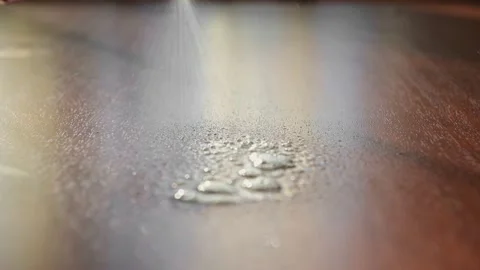 Close-up hand in a glove splashes detergent on brown table and wipes it. Stock Footage 149458788
