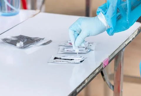 Close up hand in gloves testing ATK on white table. Stock Photos