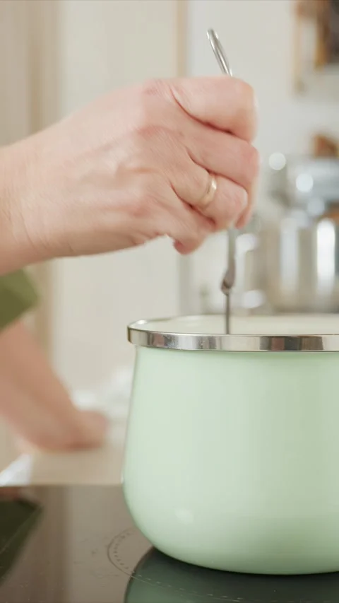 Close up hand with gold ring repeatedly lifts metal hook into light green Video stock 345669737