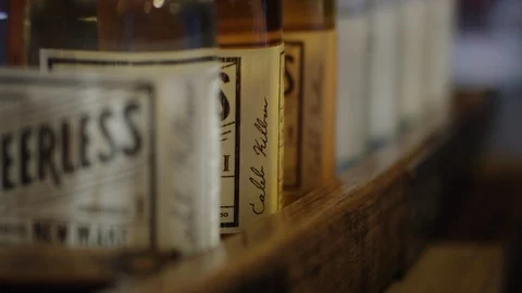 Close up of hand grabbing a bottle of bourbon off a shelf 動画素材 113701235