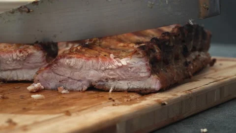 Close-up hand grabbing a piece of grilled meat and seasoning it with cream to Vidéo 178466788