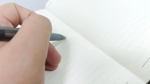 Close-Up of a Hand Gracefully Writing in a Lined Notebook with a Pen, Showc.. Stock Photos