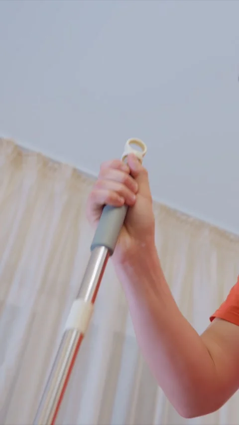 Close up of hand gripping and adjusting mop handle during domestic cleaning task Stock Footage 346792059