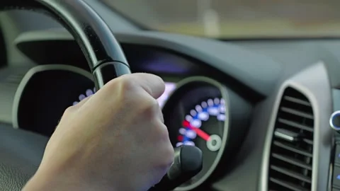 A close-up of a hand gripping the steering wheel of a car, showcasing dashboard Stock Footage 300235706