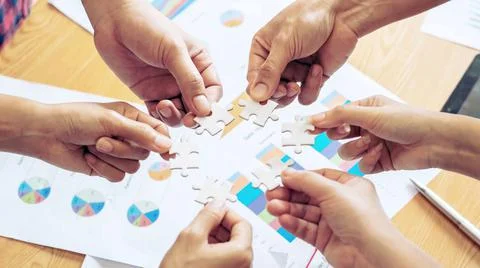 Close up hand of group business partnership people puting together a jigsaw p Stock-Fotos