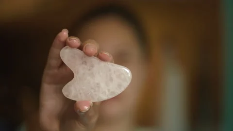 Close up in hand Gua Sha face lifting massage stone. Morning routine. Stock Footage 169419079