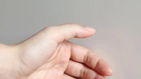 Close up of a hand having a spasm in the thumb, involuntary muscle contraction Stock Footage