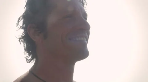 Close up hand held of an attractive man with sun glare standing in the ocean Stock Footage 57585649