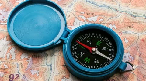 Close up of a hand held compass against map Stock Footage 21314899