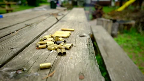 Close up hand held  shot of bullet shells laying on old wood table Stock Footage 311486348