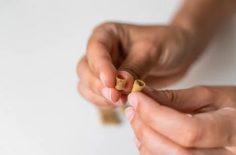 Close up hand with herb capsule on white background. Microdosing concept Stock Photos