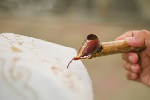 Close up of hand hold canting is tool for make batik with isolated white ba.. Stock Photos