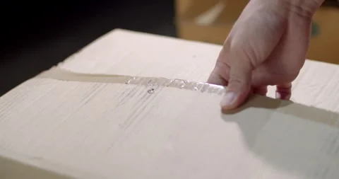 Close up hand hold Cutter Knife cut tape attached on the delivery box. Stock Footage 306395652