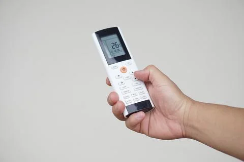 Close up hand hold remote control of air conditioner. Concept, electronics equip Stock Photos