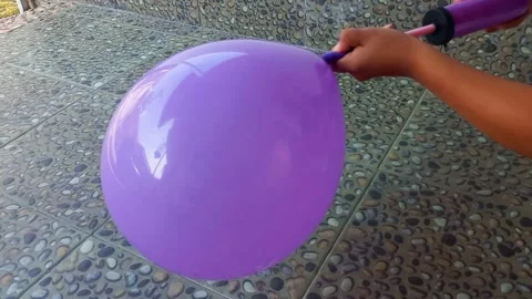 Close up hand holding and pumping a balloon Stock Footage 236371761