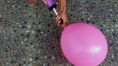 Close up hand holding and pumping a balloon Stock Footage 236372030
