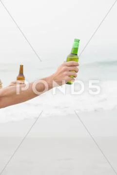 Close Up Of Hand Holding Beer Bottle On The Beach