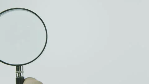 Close Up Hand Holding Big Magnifying Glass and Scanning From Right to Left Stock Footage 292040422