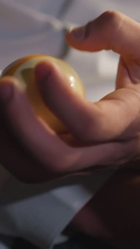 Close-Up of Hand Holding Billiard Ball and Open Book in Dramatic Lighting Video stock 319791459
