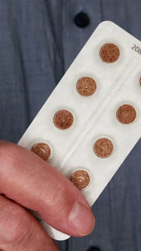 Close-Up Of A Hand Holding A Blister Pack With Circular Brown Tablets. Vertical. Video stock 306188078