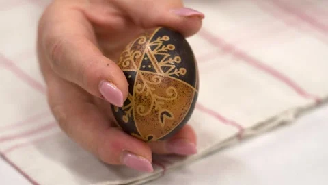 Close-up of a hand holding a brown and black decorated Hungarian Easter egg Video stock 307185964
