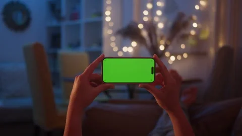 Close-up of hand holding chroma key green screen in horizontal position without Stock Footage 285932995