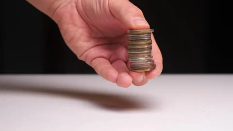 Close-up of a hand holding coin stack on black background Vídeo Stock 258601955