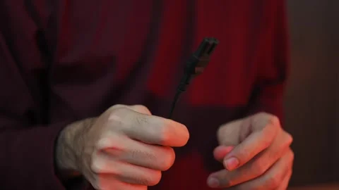 Close Up of Hand Holding DC Power Connector Cable with Blurred Background Stock Footage 337847346