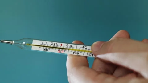 Close-up of a hand holding a glass thermometer to measure temperature Stock Footage 340264752
