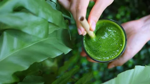 Close-up of hand holding green smoothie in glass glass against background of Stock Footage 258917172
