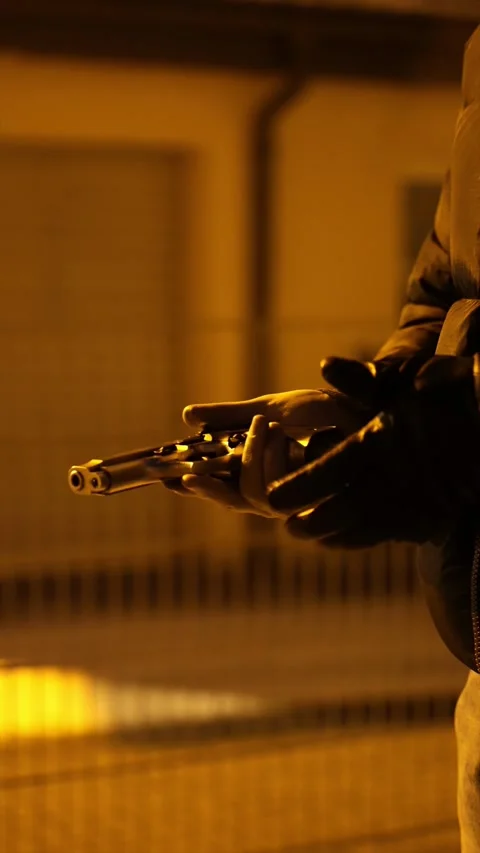 Close-Up of Hand Holding Gun at Night in Slow Motion Vidéo 325448861