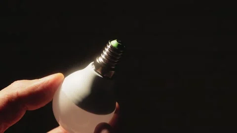 Close-up hand holding a light bulb in the dark. Stock Footage 165435656