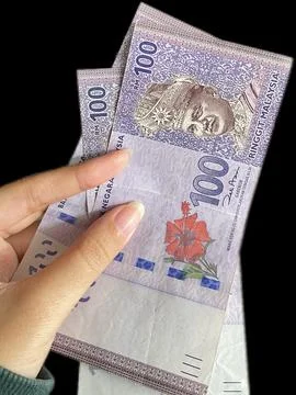 Close up of Hand Holding Malaysian Ringgit RM100 Banknotes Stock Photos