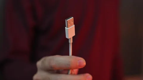 Close Up of Hand Holding Micro USB Charging Cable Connector with Blurred Bac Stock Footage 337847358