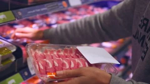 Close-up hand holding packaging fresh meat, choosing through bacon on shelf Stock Footage 268542591