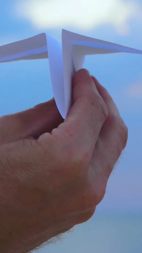 Close-up of hand holding paper airplane against blue sky. Creative concept Stock Footage 341867250