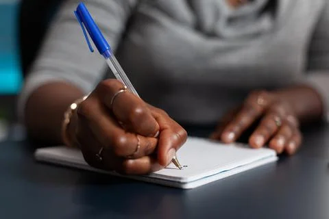 Close up of hand holding pen to write on textbook file Stock Photos