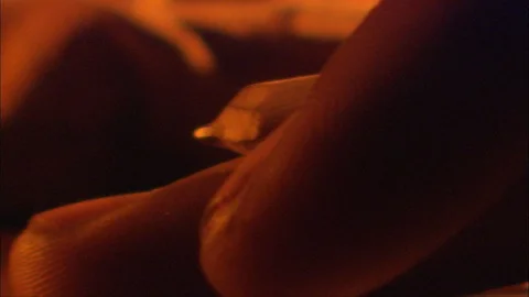 Close-Up of a hand holding a pencil - tabletop writing by candlelight Stock Footage 91144239