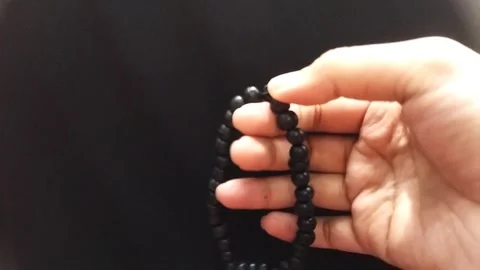Close Up Hand Holding Prayer Beads on Dark Background Stock Footage 325662994