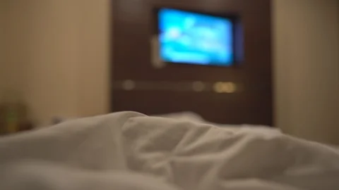 Close up hand holding remote and select chanel for looking television on bed Vidéo 122886393