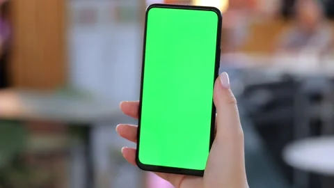 Close-up of hand holding smartphone with green display Stock Footage 345678083