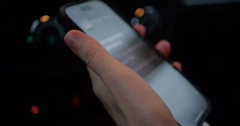Close-up of a hand holding a smartphone inside a car at night... Stock Footage 319882674