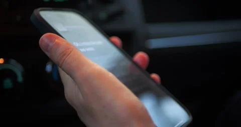 Close-up of a hand holding a smartphone inside a car... Stock Footage 319882715