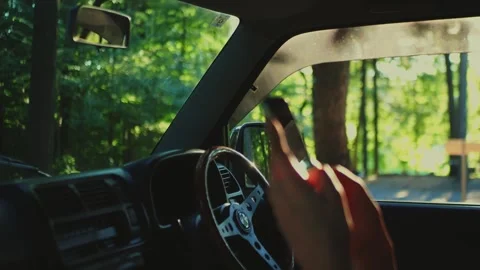 Close-up of a hand holding a smartphone inside a car parked near... Stock Footage 341613118